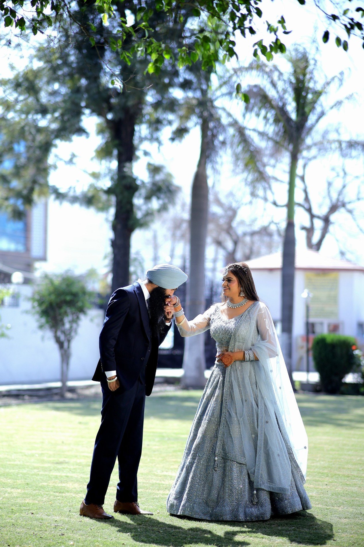 Gurkirat Singh kissing Simranpreet Kaur’s hand in a garden